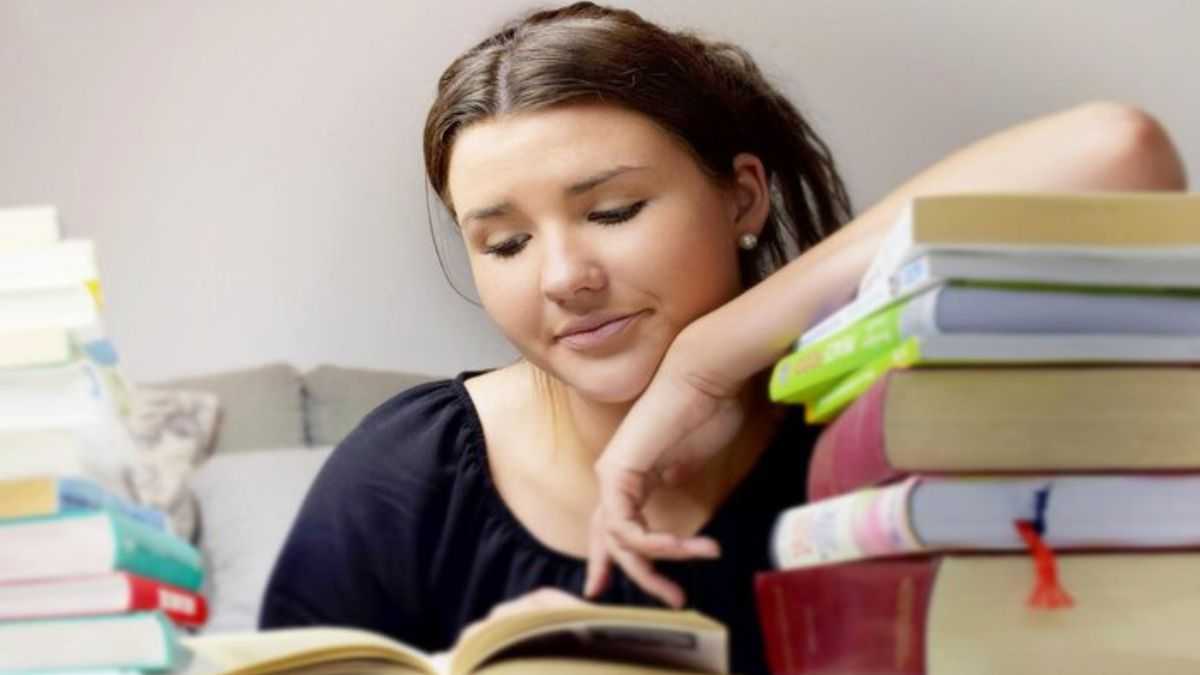 moça jovem estudando com vários livros